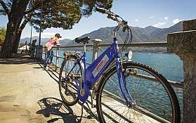 Blaues Fahrrad am See Ein blaues Fahrrad steht an einem Ufer mit Blick auf den See.