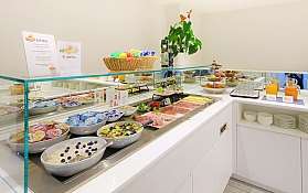 Frühstücksbuffet mit verschiedenen Speisen Vielfältige Auswahl an Speisen und Getränken auf einem Frühstücksbuffet.
